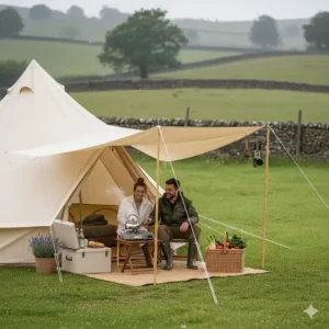 A camping stove and cool box set up under a bell tent awning to create an outdoor cooking space.