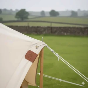 Close-up of the heavy-duty eyelets and guy lines used to secure a bell tent awning to the A-frame pole.