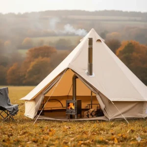 A traditional bell tent setup with a tripod fire pit and a wood-burning stove for a warm autumn camping experience in the UK.
