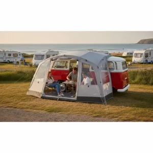 A Vango inflatable drive-away awning attached to a VW campervan at a seaside caravan park.