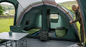 Interior view of a spacious vis-à-vis tent showing the central living section between two separate zipped sleeping compartments for families.