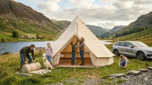 A family pitching a large polycotton tent at a UK holiday park, showing the central pole and high-quality guy lines.