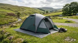 A detailed 4K view of a green dome tent with its dark grey footprint correctly tucked beneath the edges to prevent rain from pooling.