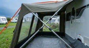 Adjustable steel storm poles reinforcing a caravan awning during a typical British summer thunderstorm.
