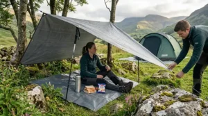 An illustration showing how a secondary groundsheet can also be used as a temporary rain shelter or picnic rug during a trek in the Lake District.