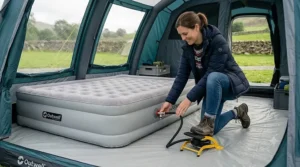 Using a versatile camping foot pump to inflate a double airbed inside an air tent awning.