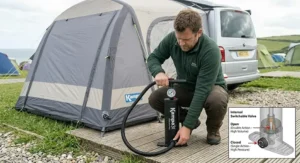 An outdoor scene showing a camper inflating a drive-away air awning next to a VW campervan using a heavy-duty double action pump.