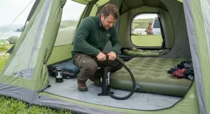 A person inside a tent using a double action pump camping to quickly inflate a double flock camping airbed.