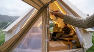 A close-up of a hand installing a flexible LED strip light along the inner edge of a tent awning.