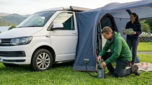 A portable rechargeable pump inflating a drive-away airbeam awning attached to a campervan.