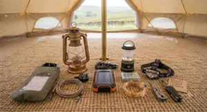 A clean flat-lay photo of a complete camping lighting kit, including different-sized lanterns, two headlamps, string lights, a power bank, and a pack of spare batteries, all laid out systematically.