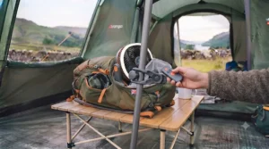 A close-up view showing the secure hook design of a hanging tent fan attached to a tent pole.