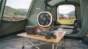 A modern, rechargeable USB tent fan being charged with a portable power bank inside a tent.