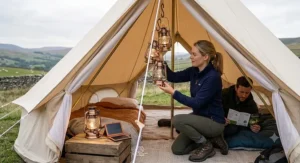 A close-up of a range of eco-friendly, modern solar lanterns and inflatable solar-powered lights on a table outside a tent, showing a variety of sustainable lighting options for UK camping.