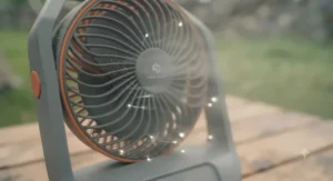 A close-up of the battery powered tent fan with integrated LED light ring illuminated.