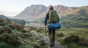 Hiker carrying a backpack equipped with a lightweight summer sleeping bag for a weekend trail trek.