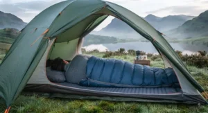 Camper resting comfortably inside a dome tent using a cosy summer sleeping bag.