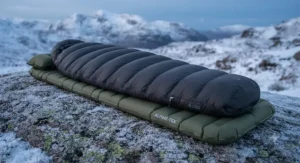 A heavy-duty winter sleeping bag packed tightly into a waterproof compression sack for backpacking.