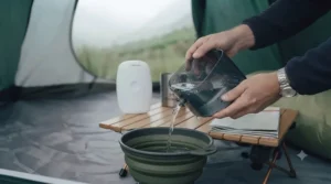 Emptying the small water collection tank of a camping dehumidifier.