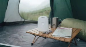 Sleek mini dehumidifier on a wooden camping table.