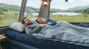A couple sleeping comfortably on a puncture-resistant double air bed for camping.