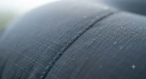 Macro shot highlighting the soft, brushed-polyester outer fabric and waterproof TPU lamination of a durable inflatable camping pillow.
