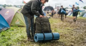 Lightweight roll mat securely strapped to the outside of a hiking rucksack packed for a weekend music festival.