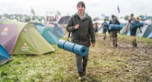Compact, lightweight roll mat rolled up tightly with a carrying strap, ready for festival travel on public transport.