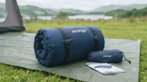 Compact rolled double air bed for camping packed neatly inside its storage carry bag.