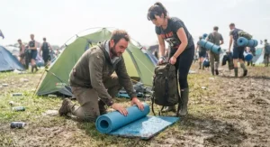 Campers quickly rolling up their festival roll mat on a Monday morning before leaving the campsite.
