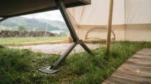 Wide-base feet on a raised camp bed providing stability on uneven grass at a festival.