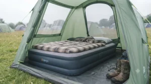 A camping air bed setup inside a waterproof festival tent during an overcast afternoon in the British countryside.