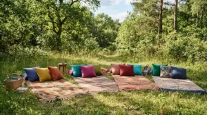 Several colourful compressible pillows for car camping arranged on sleeping bags for a family pitch outdoors.